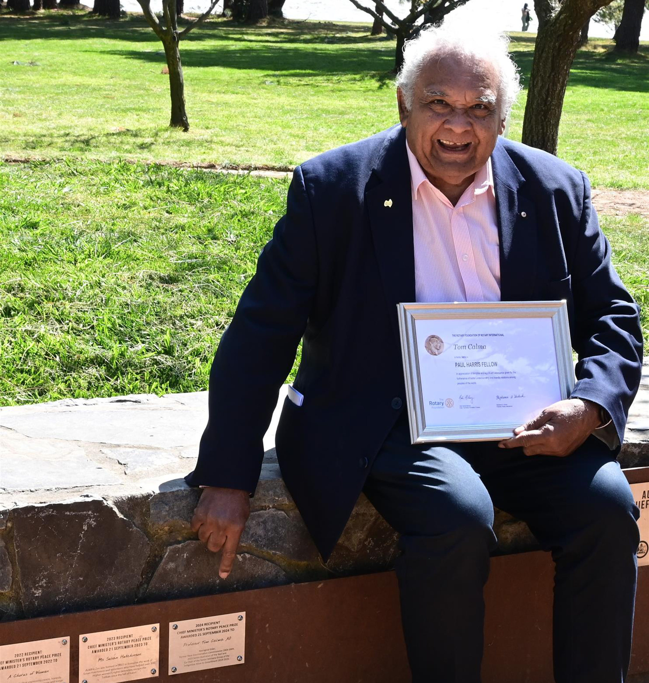 Fred Smith with guitar in front of the Canberra Rotary Peace Bell in 2021 in full colour